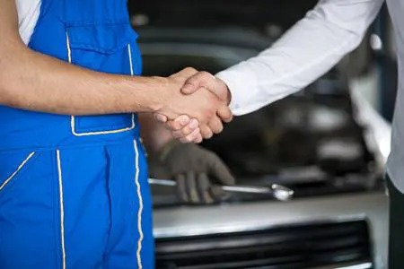 mecanico dando un apretón de manos a un cliente