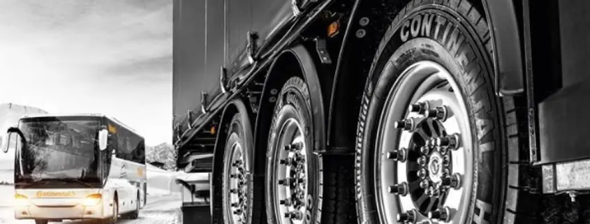 Imagen de un camióny un autobús circulando sobre una carretera nevada