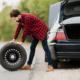imagen dfe un hombre sacando una rueda de repuesto del maletero del coche
