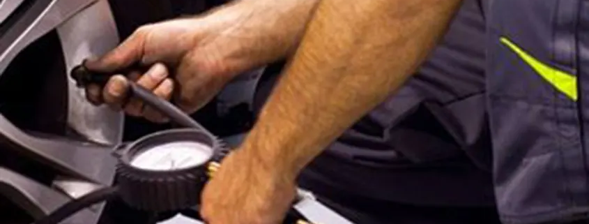 mecánico comprobando la presión de un neumático